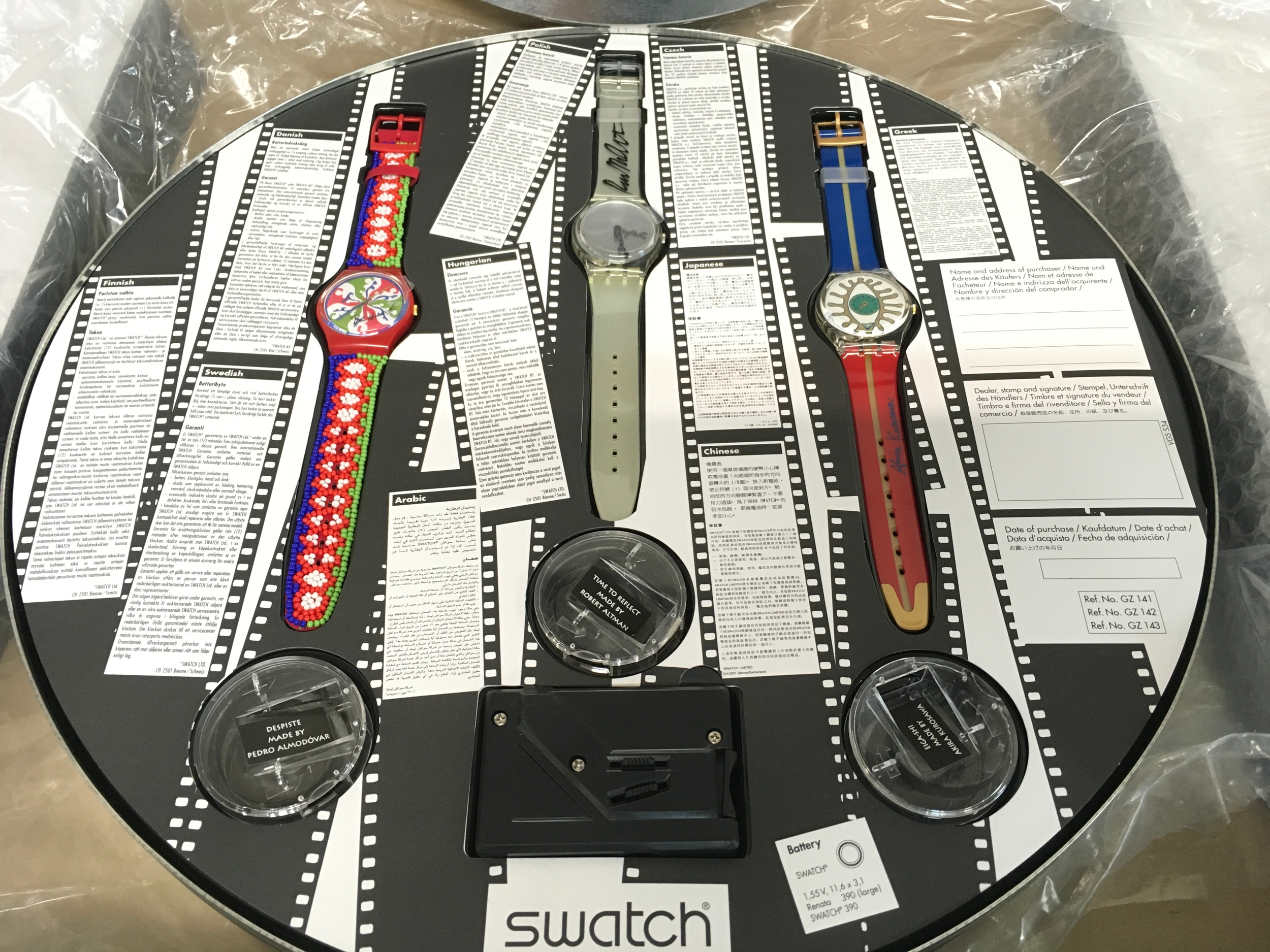 A Swatch "100 Years of Cinema" boxed set from 1995 featuring three limited edition watches in a metal film canister case. The set includes "Eiga-Shi" (GZ141) by Akira Kurosawa, "Despiste" (GZ142) by Pedro Almodóvar, and "Time to Reflect" (GZ143) by Robert Altman. This specific collection was limited to 5,555 numbered sets