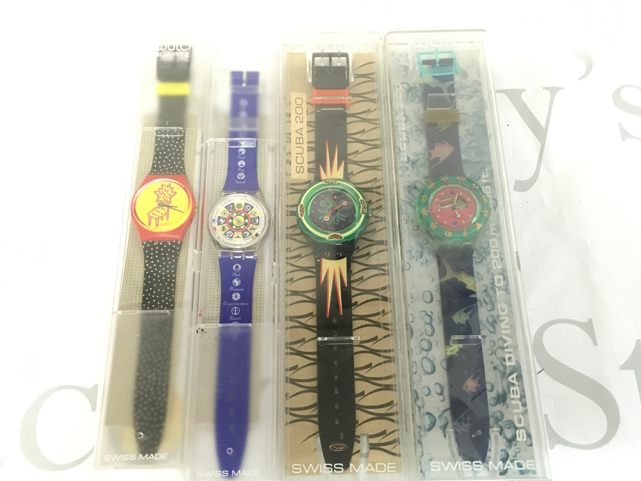 Four vintage Swatch watches from the early 1990s includes specialised scuba diving models. They come in their original packaging. Featured in this era include the Scuba 200 series, specifically designs like "Sea Floor" and "Merou".
