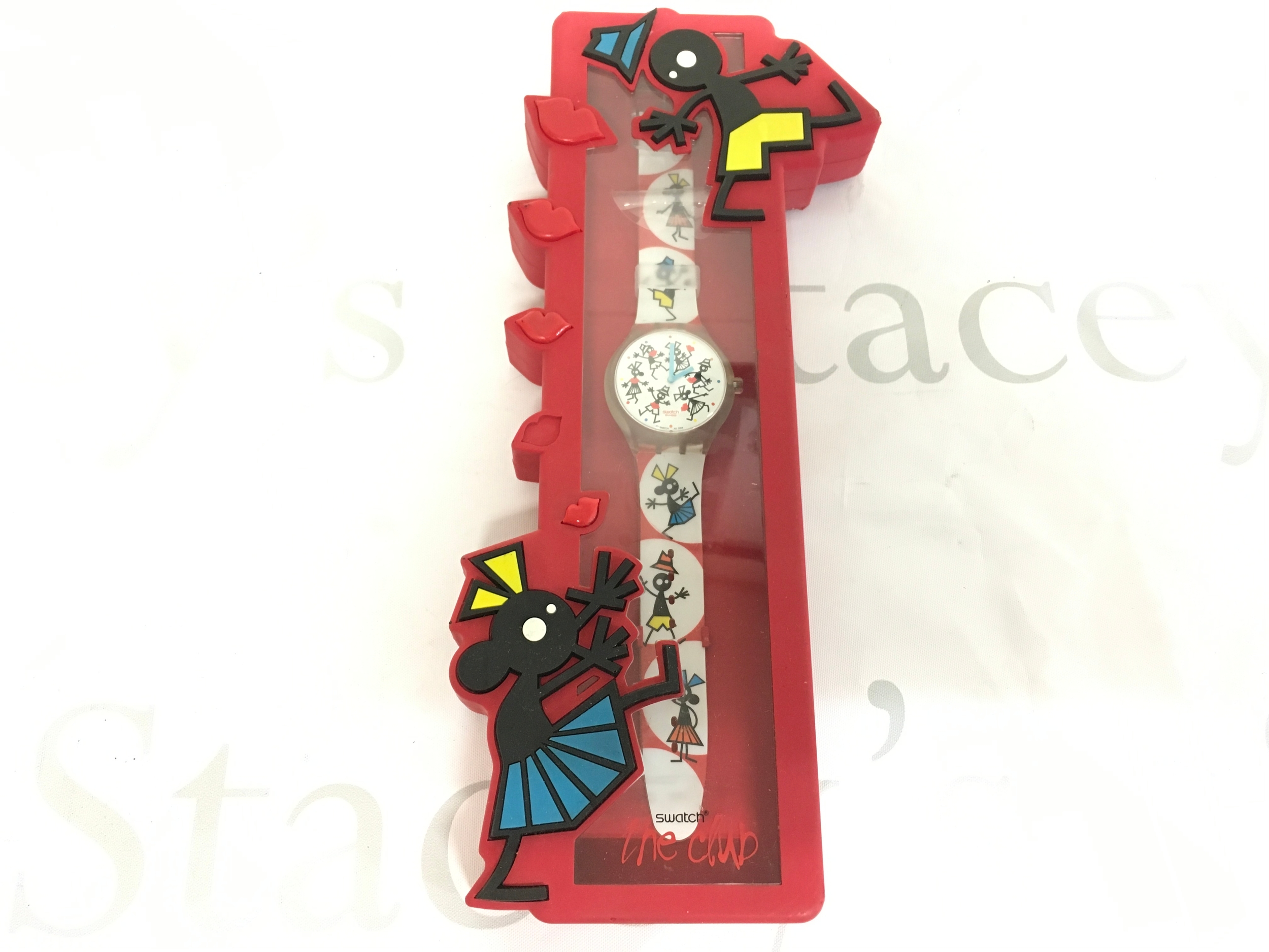 Swatch Time for a Kiss (STGK104) watch from 2004, presented in its original special red packaging. The watch features a "Touch Game" function, where tapping the face causes the hands to spin to indicate a kiss location.
