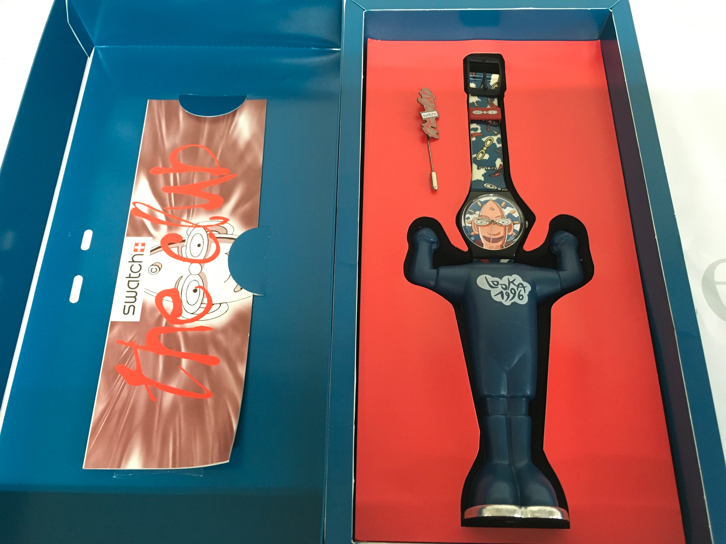 1996 Swatch Looka (GZ700) watch, designed as a "The Club" special edition. It features a stylised plastic character case and a themed strap, packaged in special blue and red display packaging.