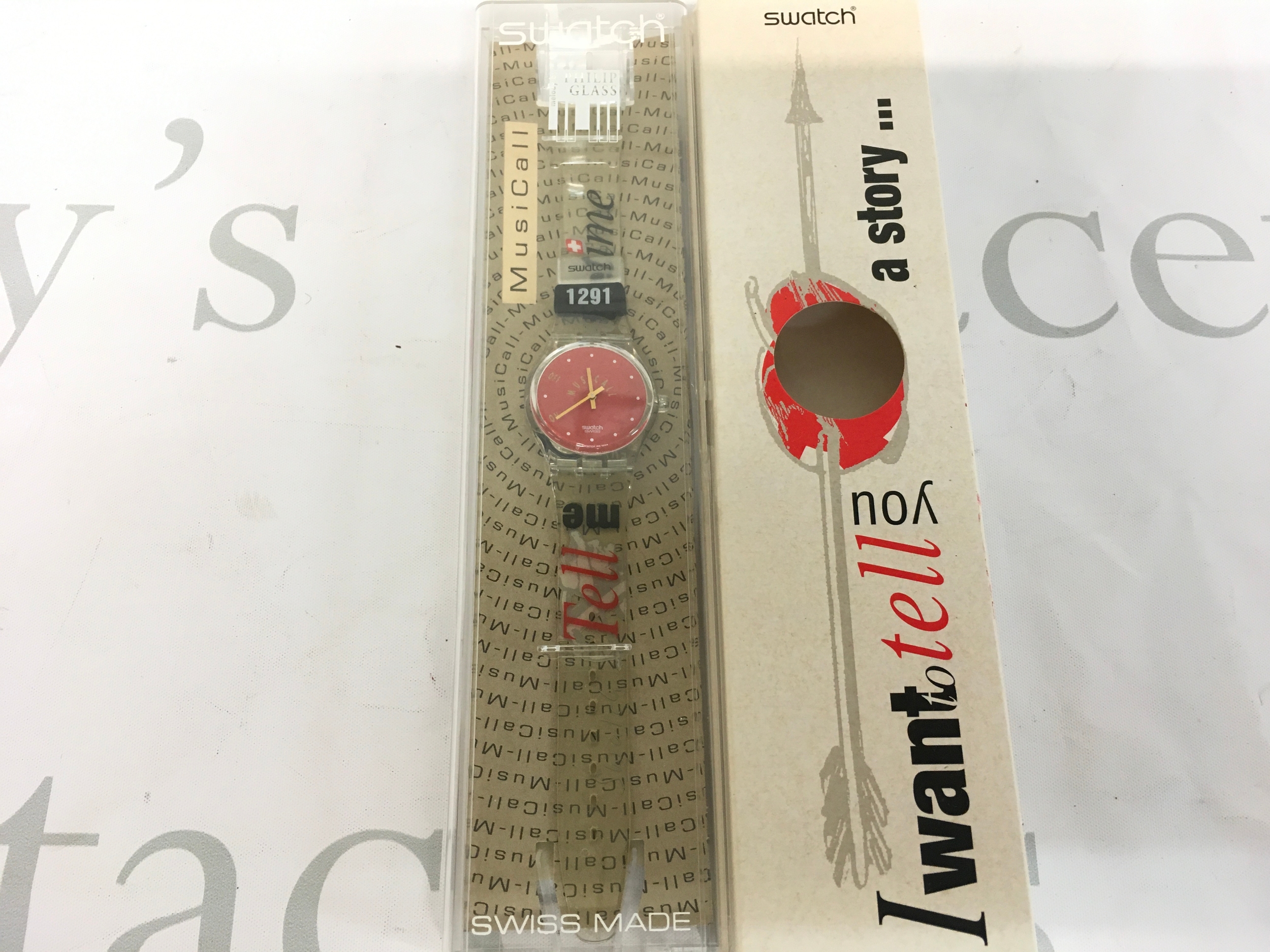 Swatch Musicall "Tell Me The Time" (SLZ100C) watch from 1997, featuring a red dial and a special themed box. It includes an integrated alarm function designed by Philip Glass