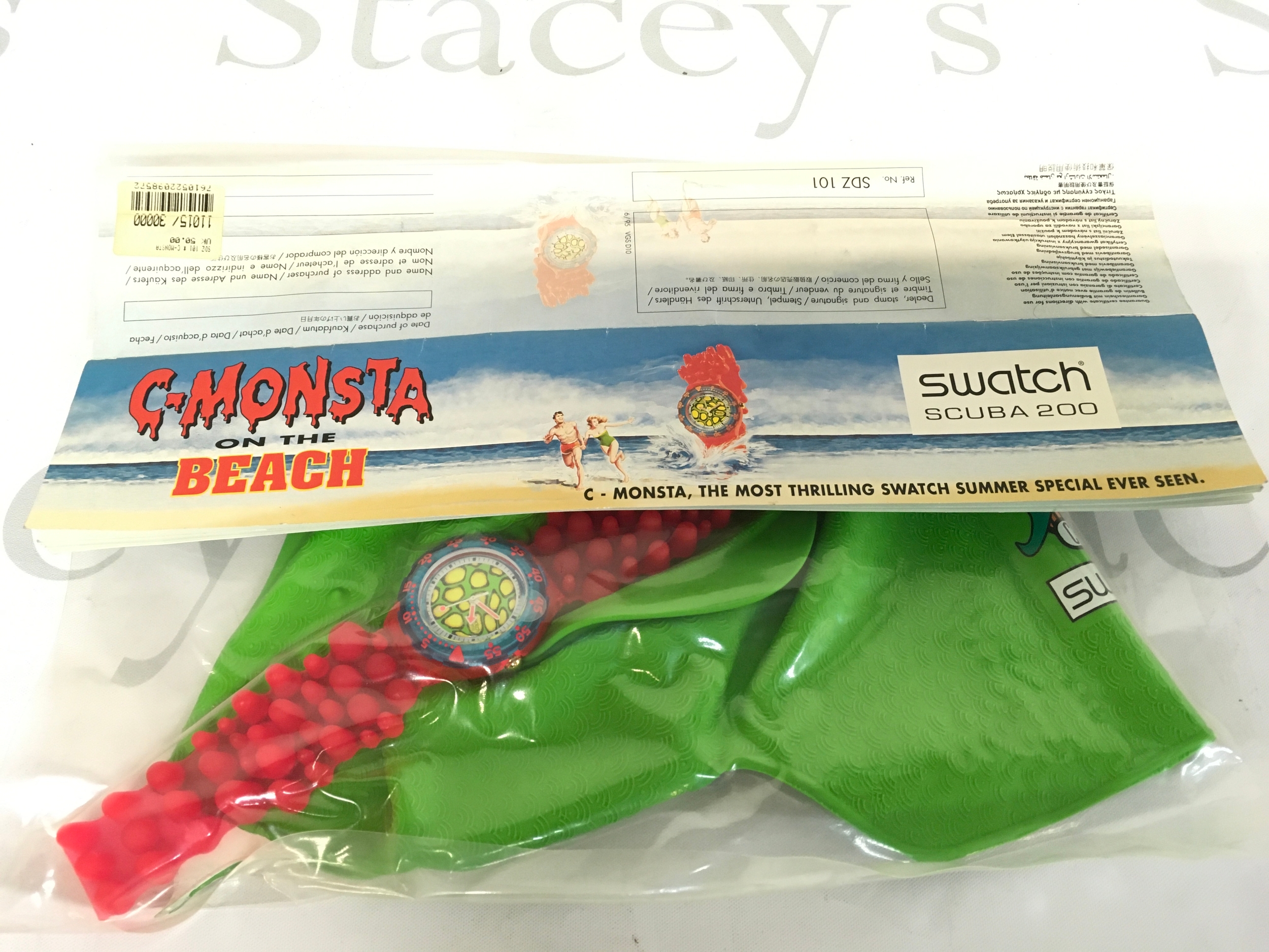 vintage 1994 Swatch Scuba 200 "C-Monsta on the Beach" watch set. The set includes a red and green watch with a colorful face, packaged with a matching green swimming cap.