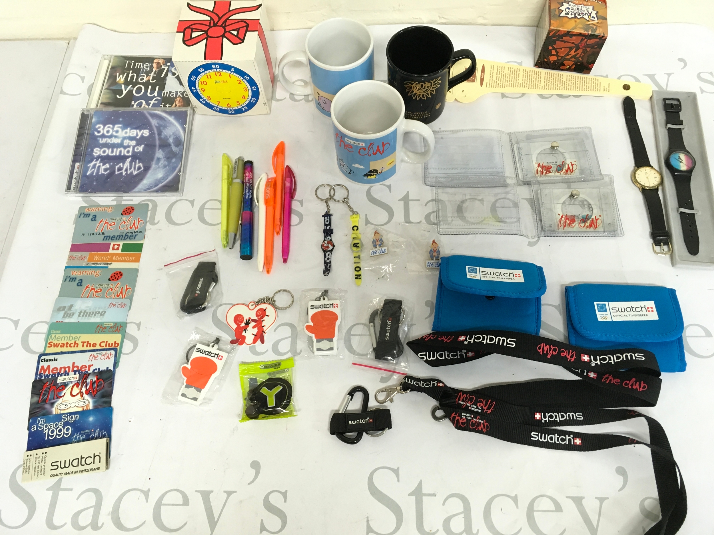 An assortment of swatch cups , pins , membership cards, wallets etc.