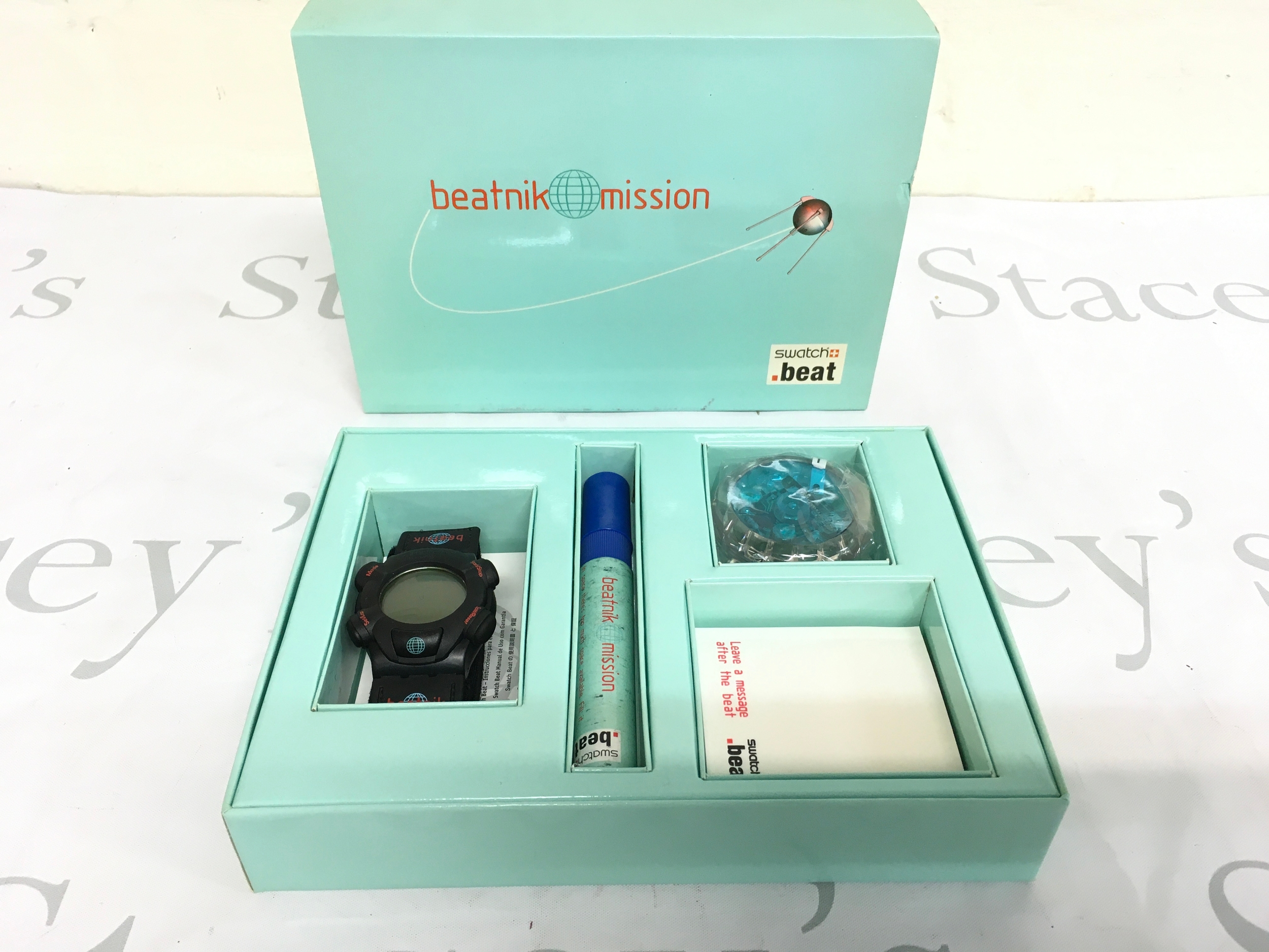 1999 Swatch Beat "Beatnik Mission" Special Edition watch set, reference number SQZ101. The set includes a digital wristwatch, a branded marker for writing on the box, and spare components.