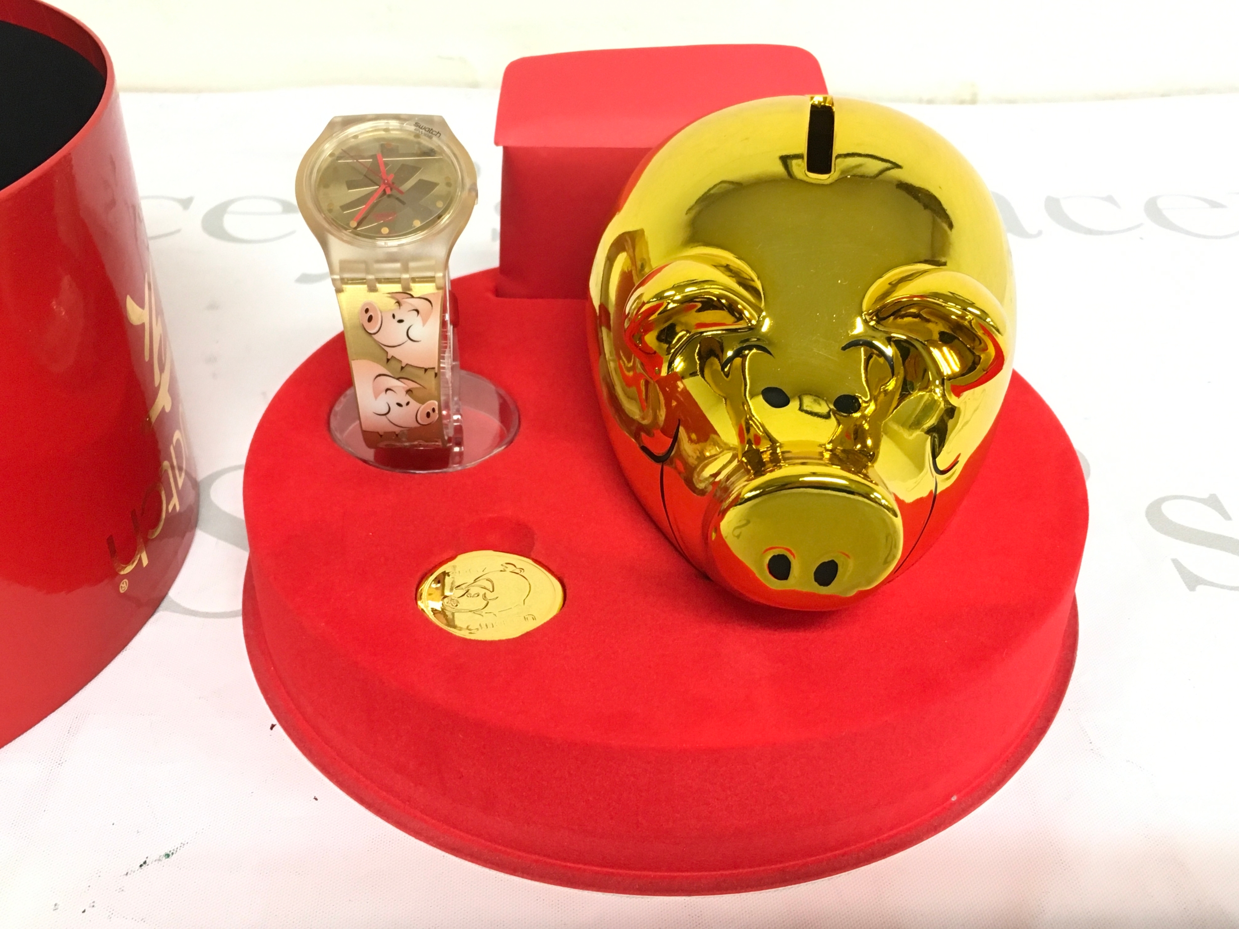 2007 Swatch "Be Lucky" (SUJK119) Chinese New Year collector's set, which features a golden piggy bank and a matching watch with pink pig illustrations on the strap.
