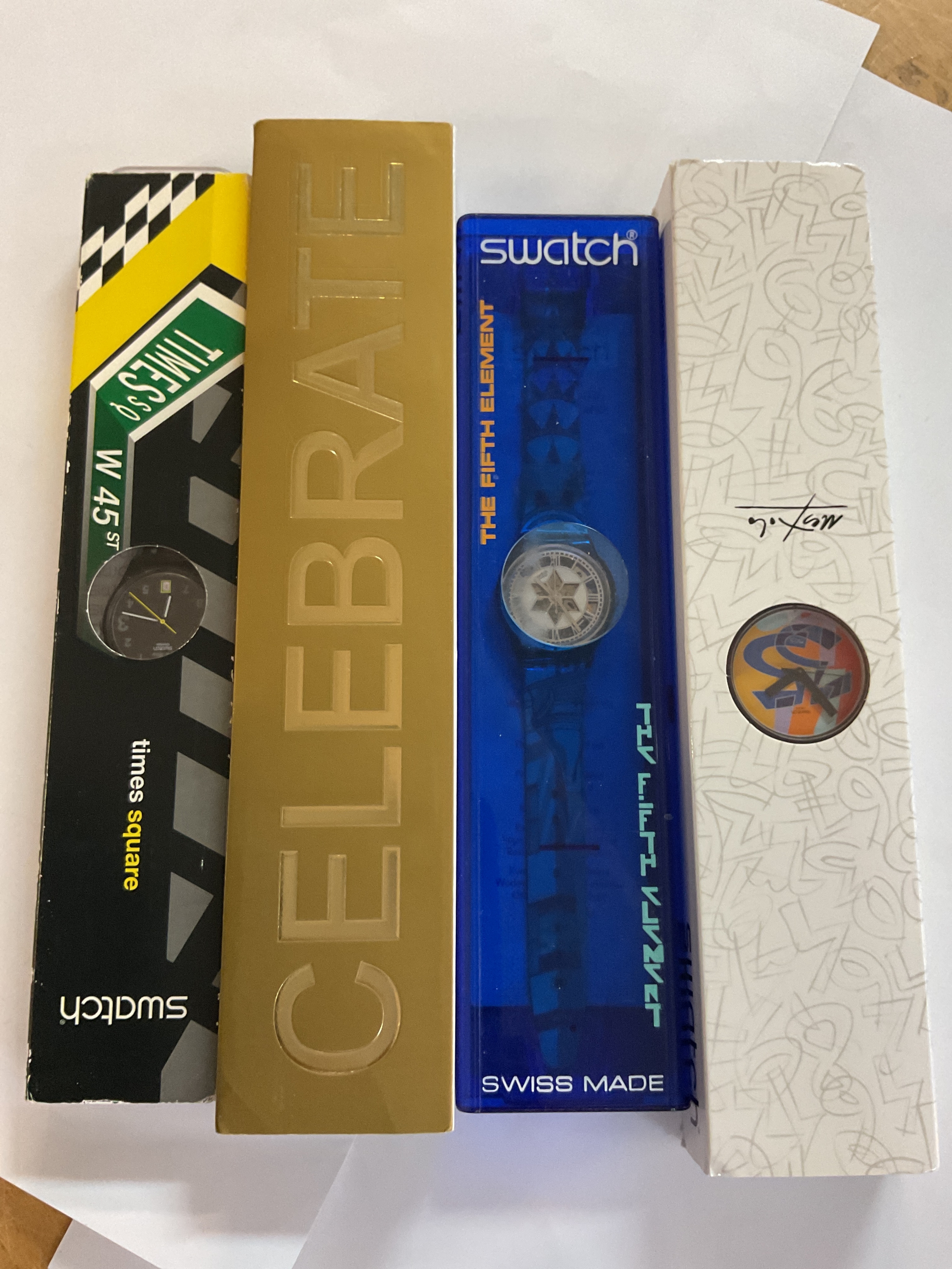 Four cased Swatch Watches.