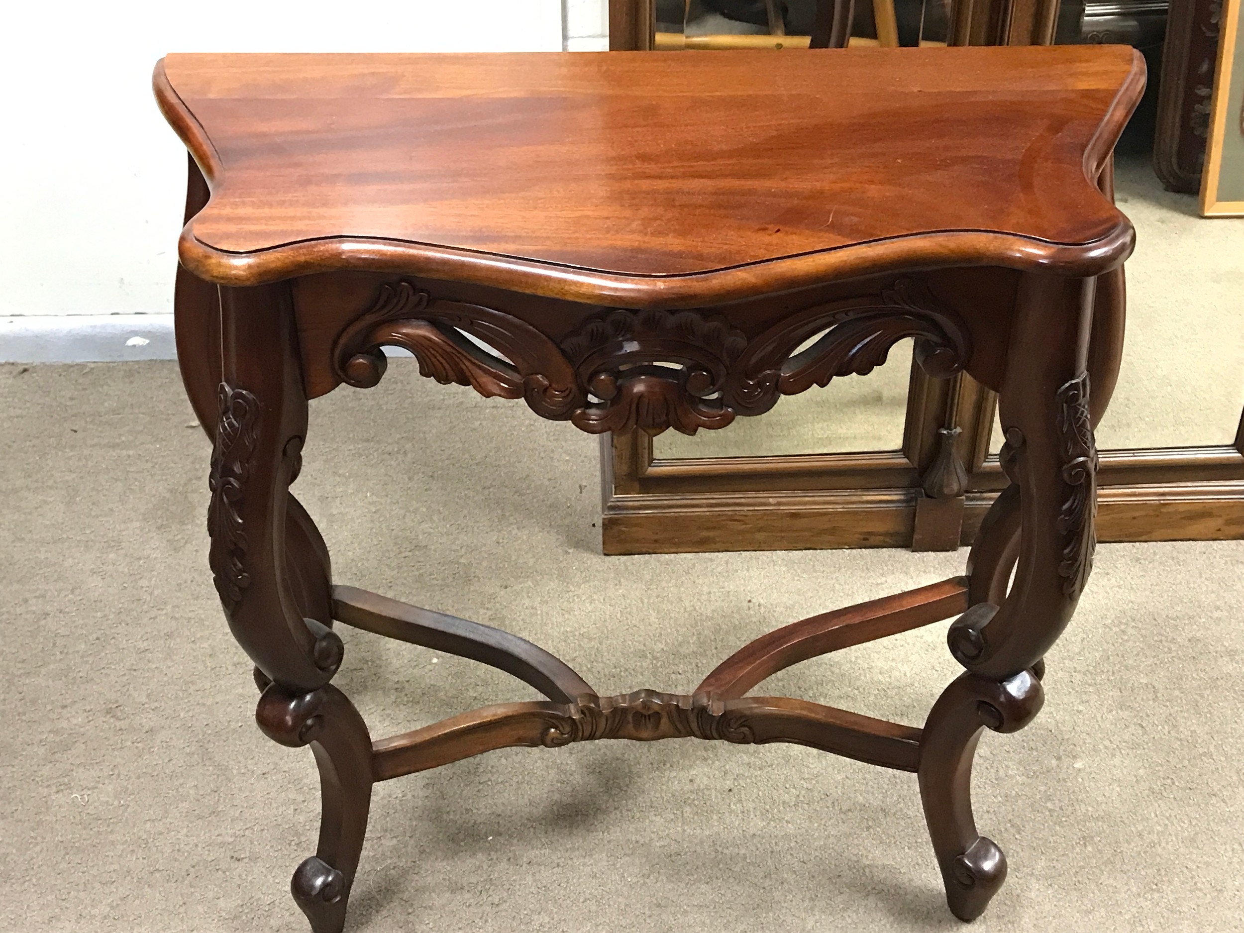 A Mahogany Victorian side table, serpentine top, cabriole legs and a cross stretcher base. 80cm wide, 75cm tall, 36cm long