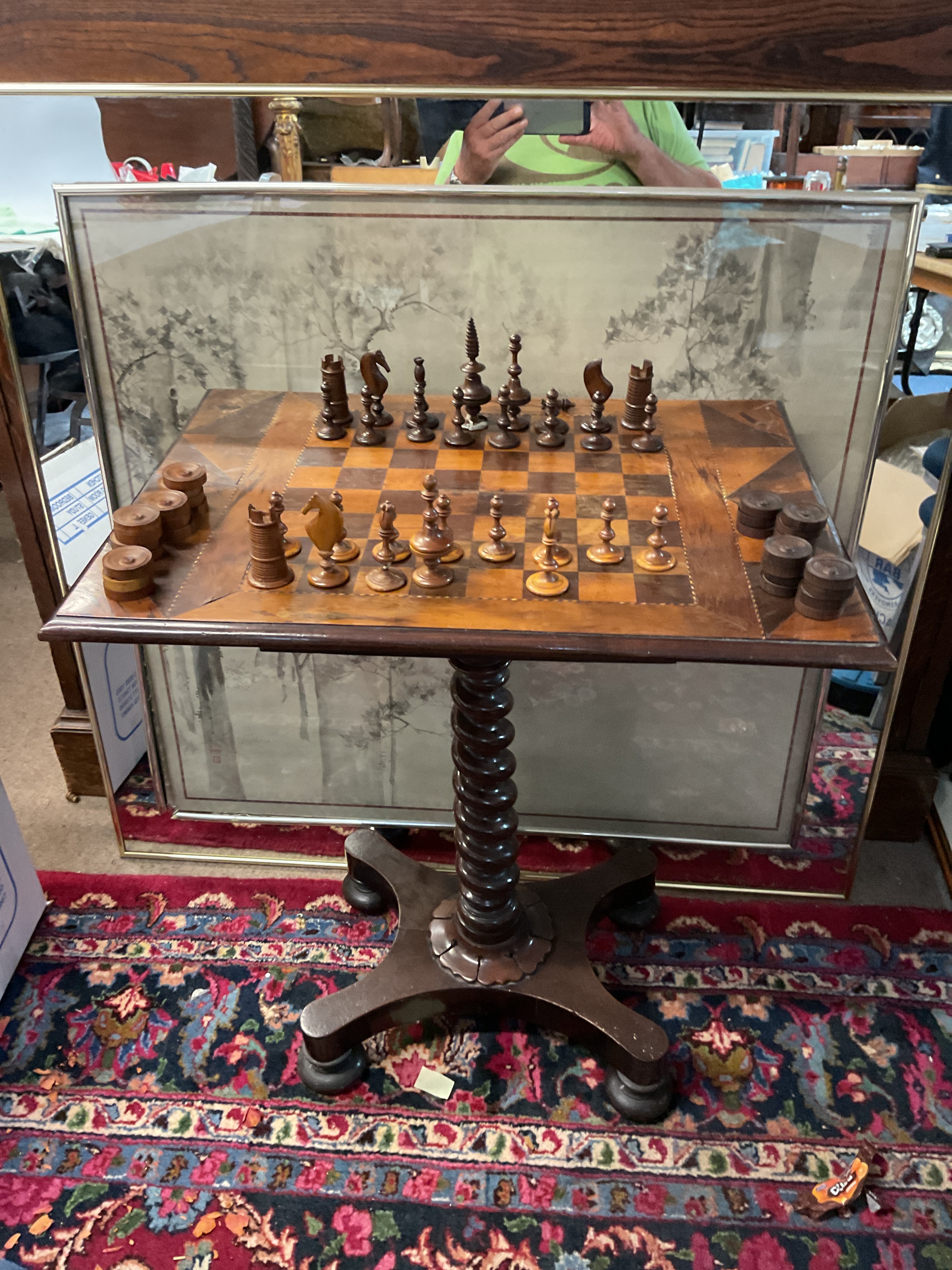 A Victorian/William IV Mahogany games table, with marquetry top and on barley twist support ending in acanthus form on four bun feet, drawer beneath set with period ornate chess and draught set.