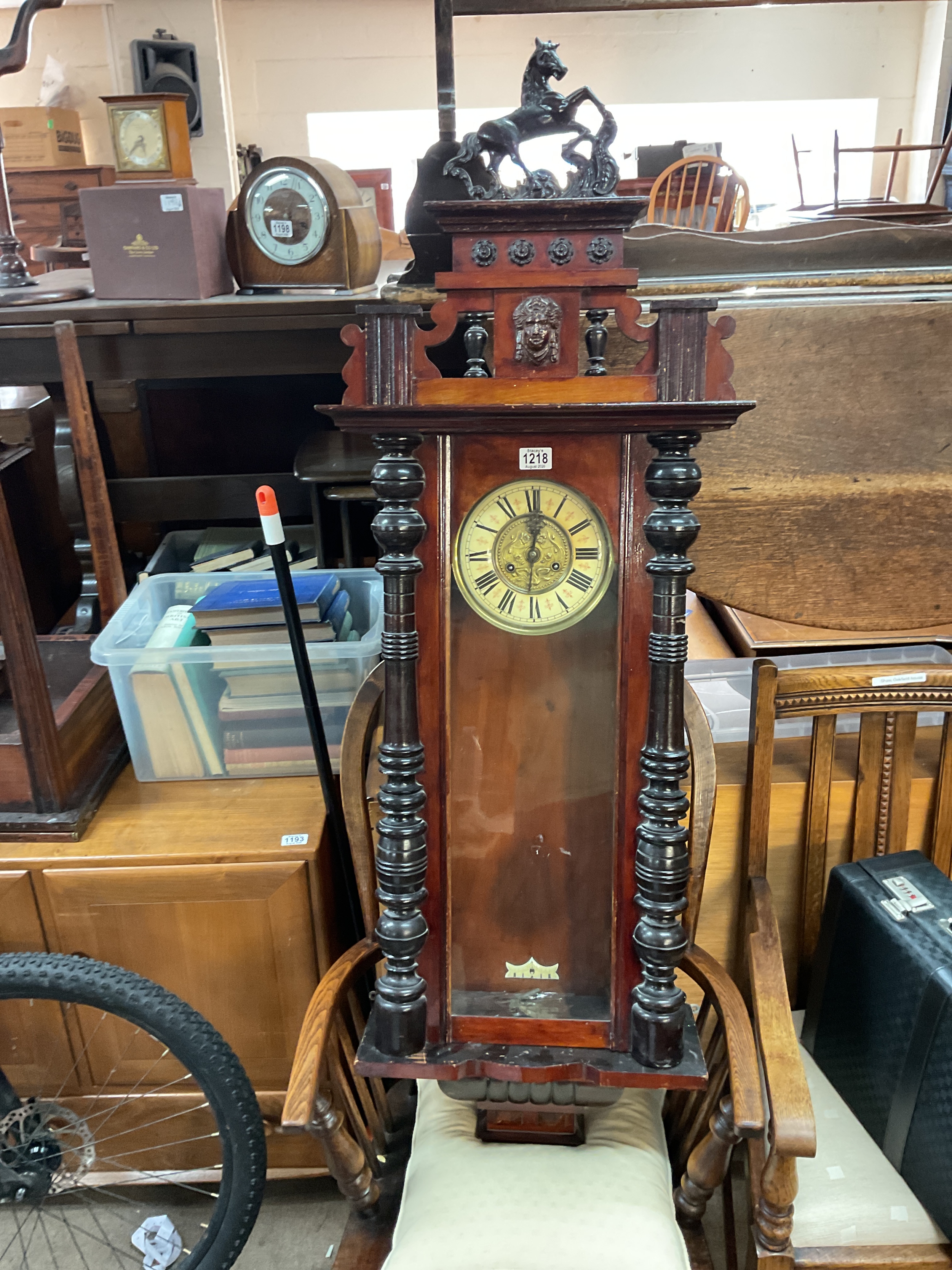 Large 19th C Mahogany wall clock with ornate fittings of a horse, eight day movement striking on a gong.
