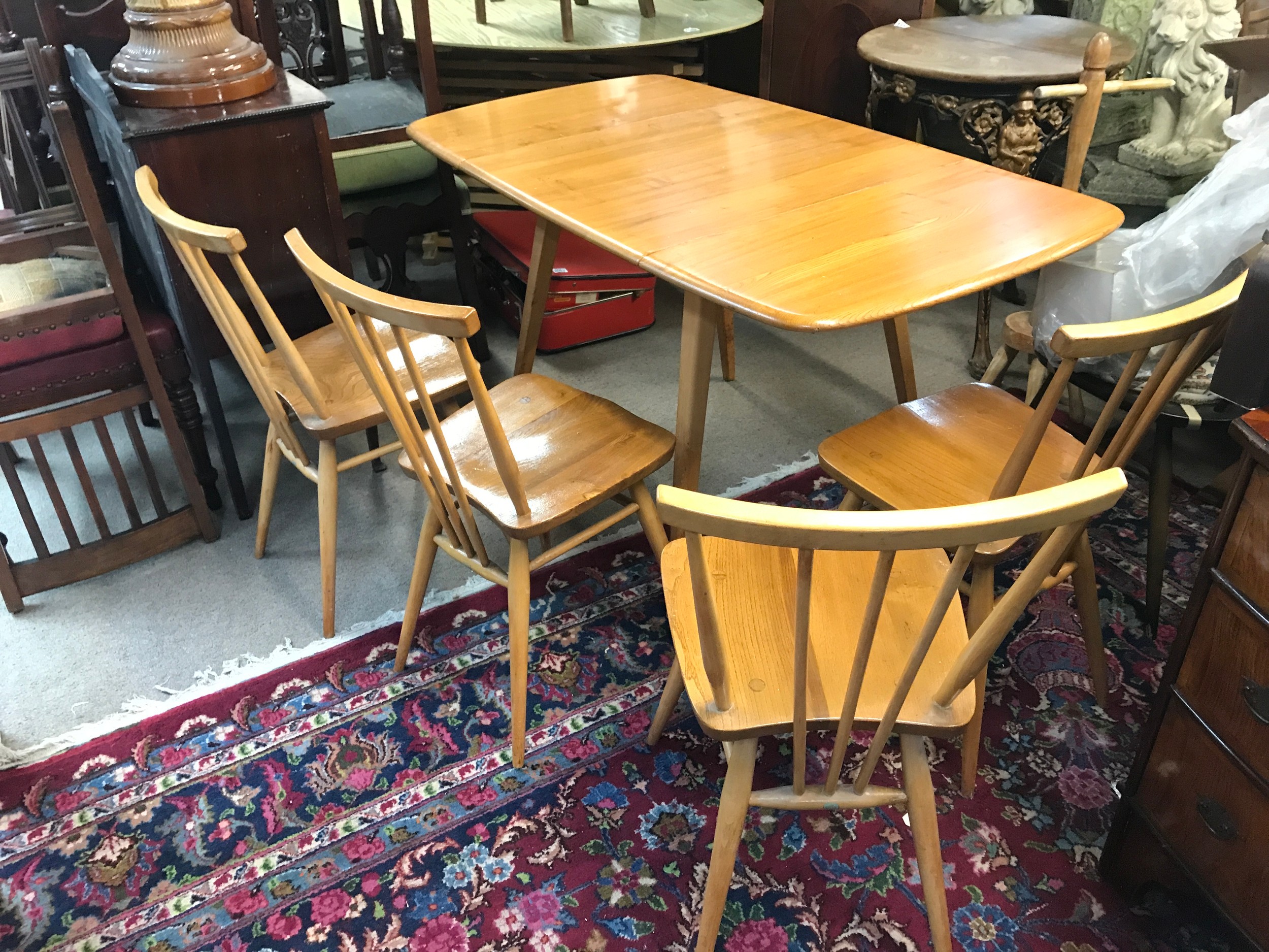 An Ercol kitchen table with four chairs. Table 135cm wide, 74cm long, 72cm tall. Chairs 80cm tall, 38cm wide, 33cm long