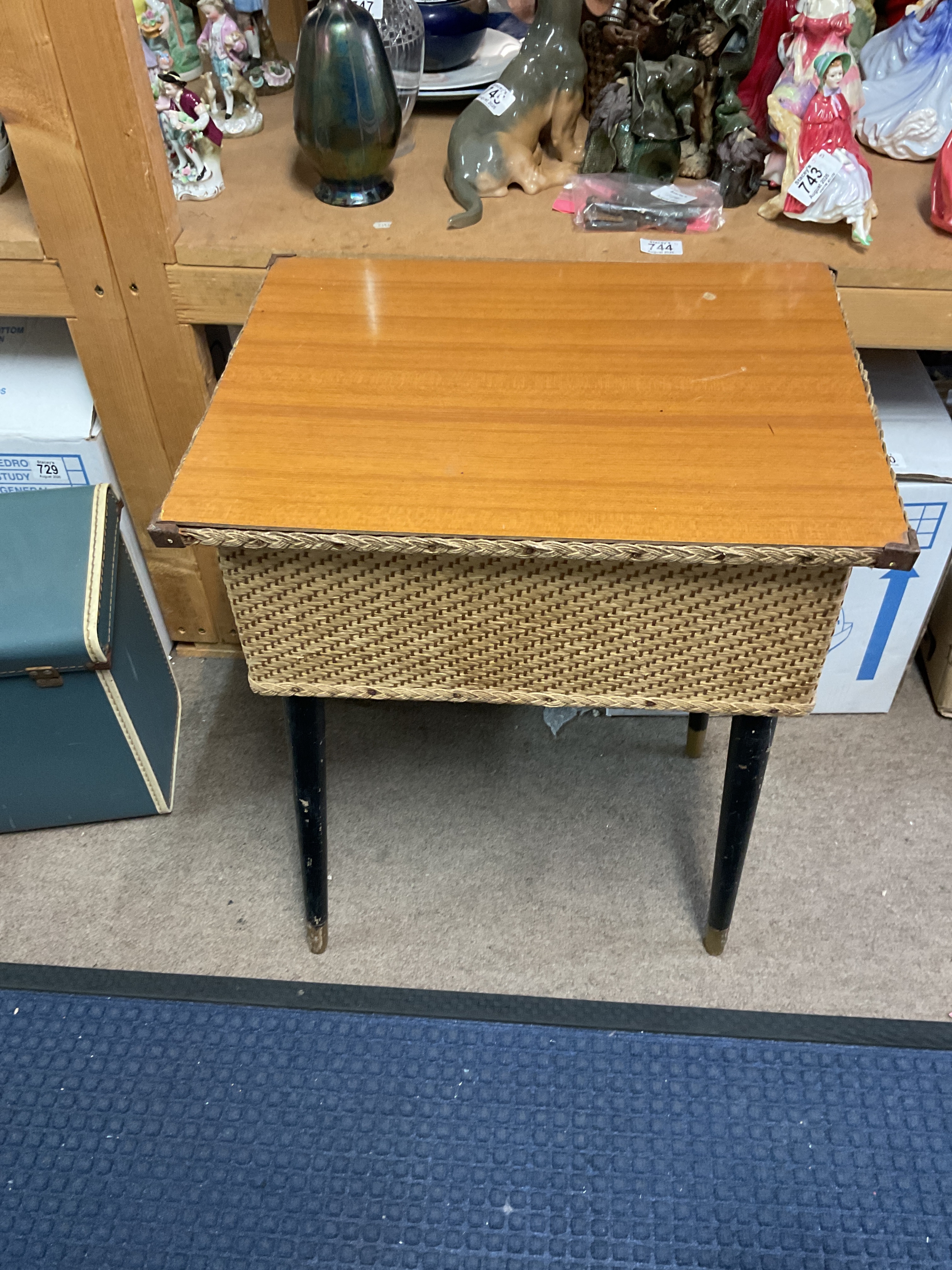 Quaint 1960s sewing/hobby table, with woven string detailing to the body and rim, lift top on period tapering legs. H58 cm x W49 cm x D38 cm.