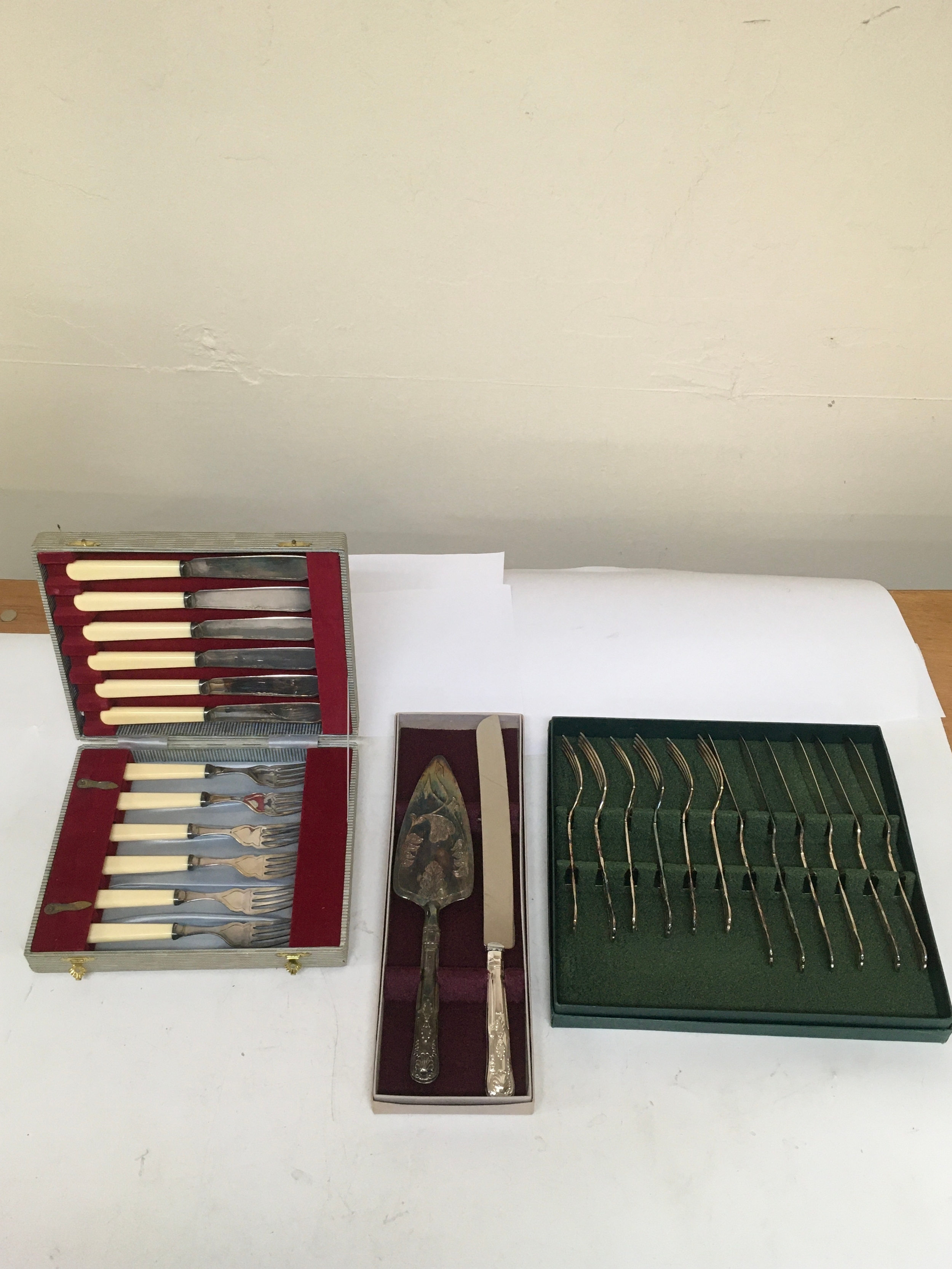 2 sets of  stainless steel Knives and forks, & 1 set of cake knife and server. All 3 sets come with cases from which they were issued. 