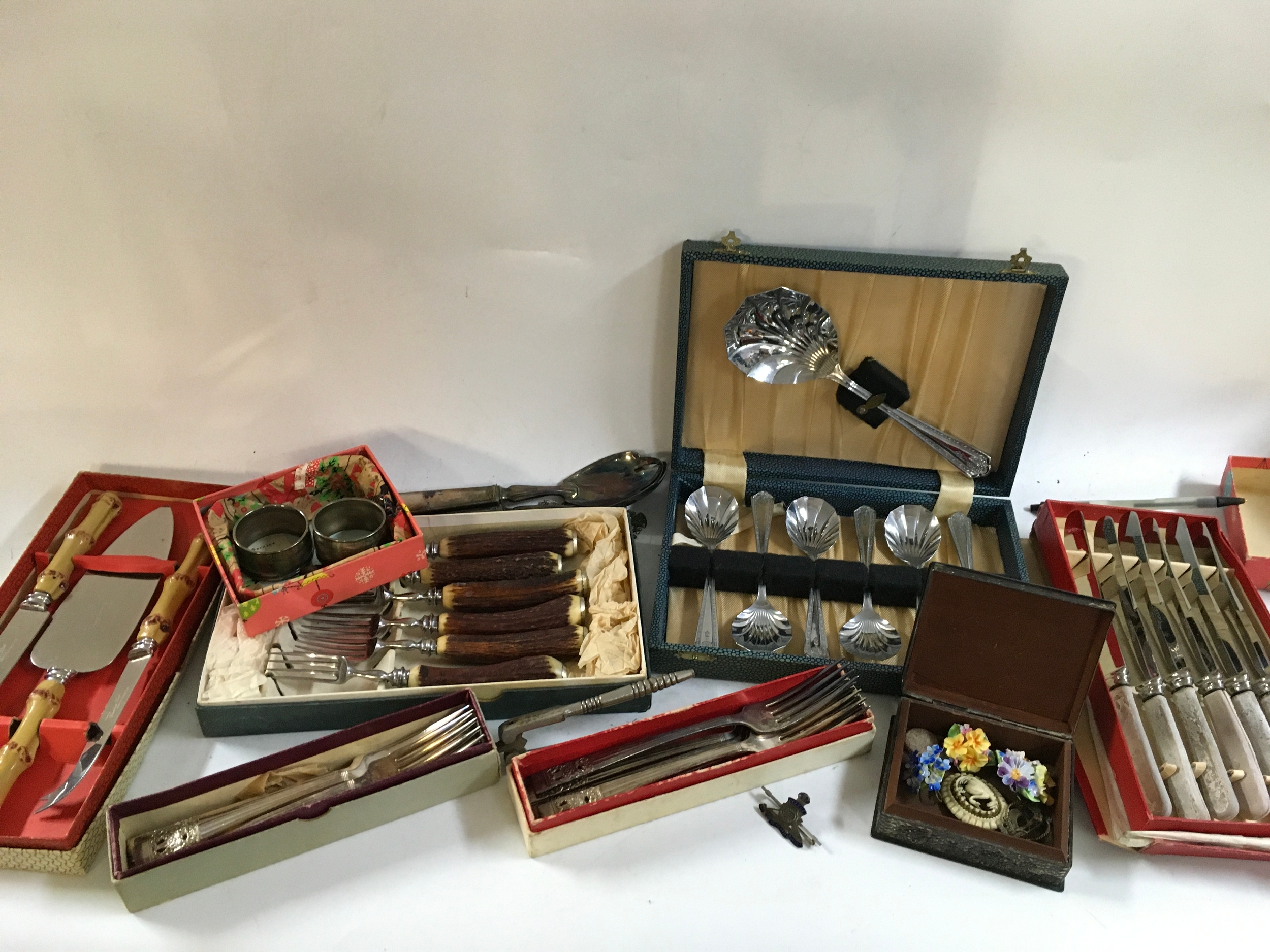 A collection of silver plated cutlery and a metal box.
