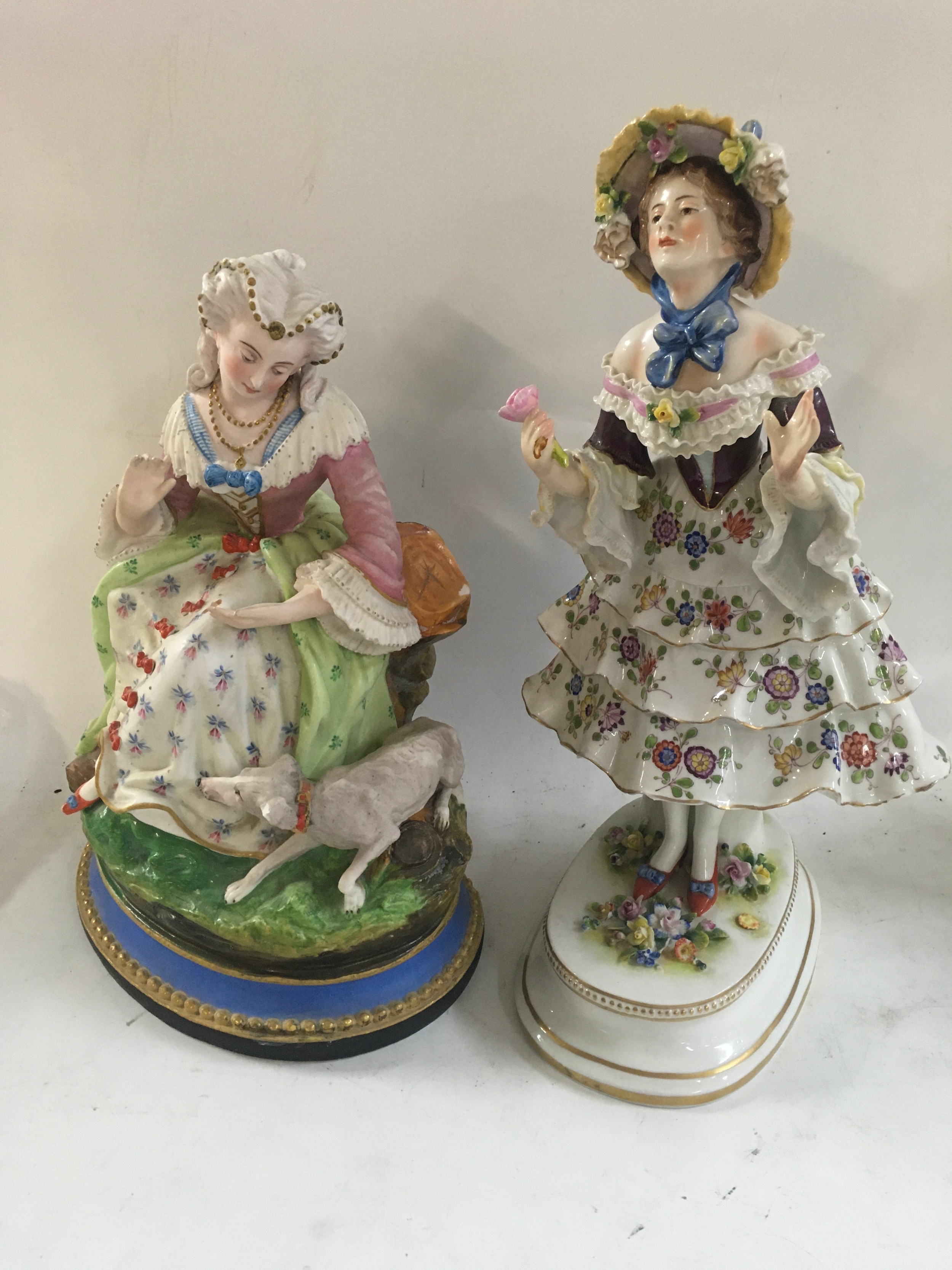 An antique glazed Capodimonte figure, Height 28cm. A bisque figurine of lady with dog, 24cm. 