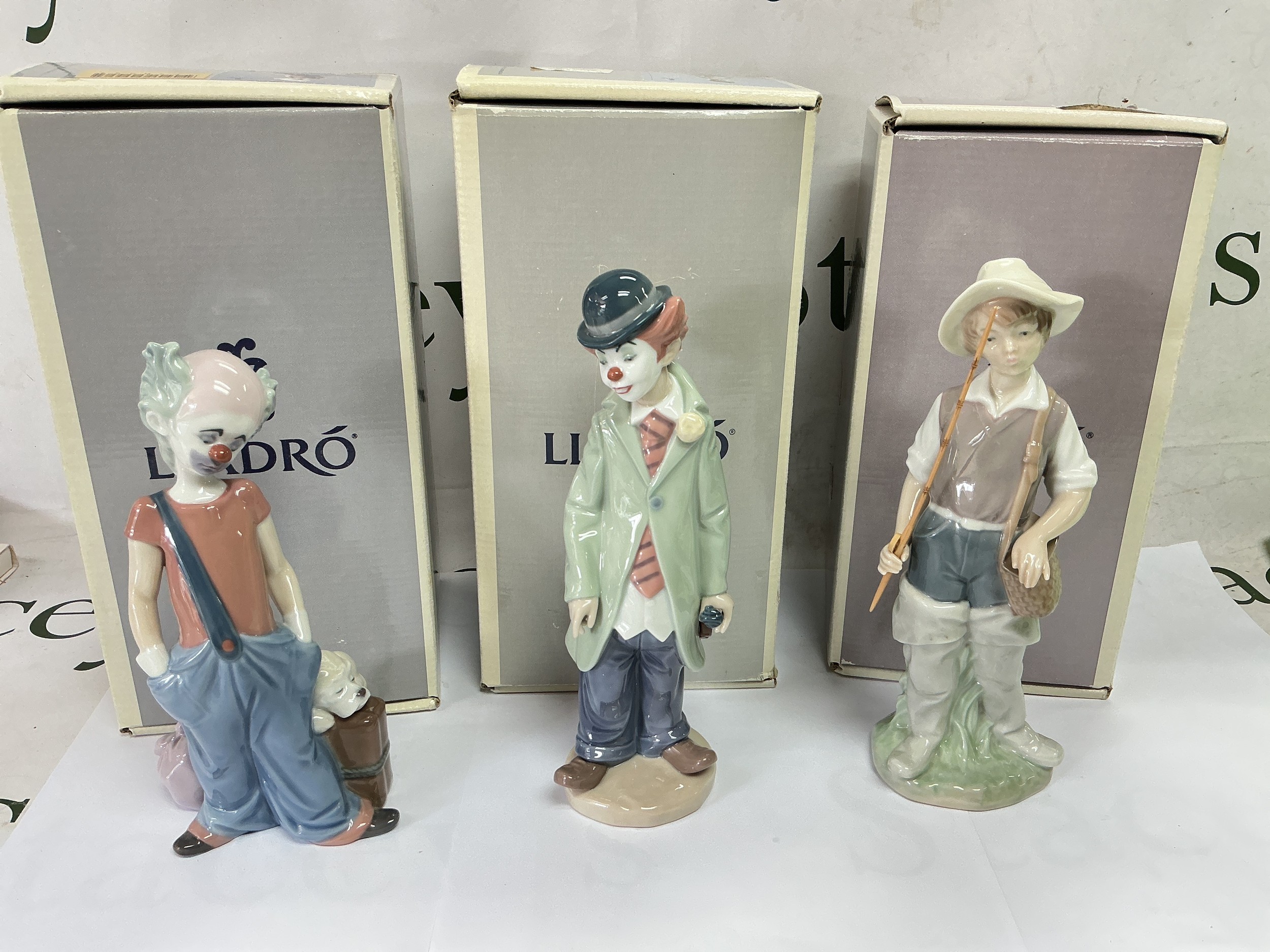 Three boxed Lladro figures comprising two clowns and a fisher boy.