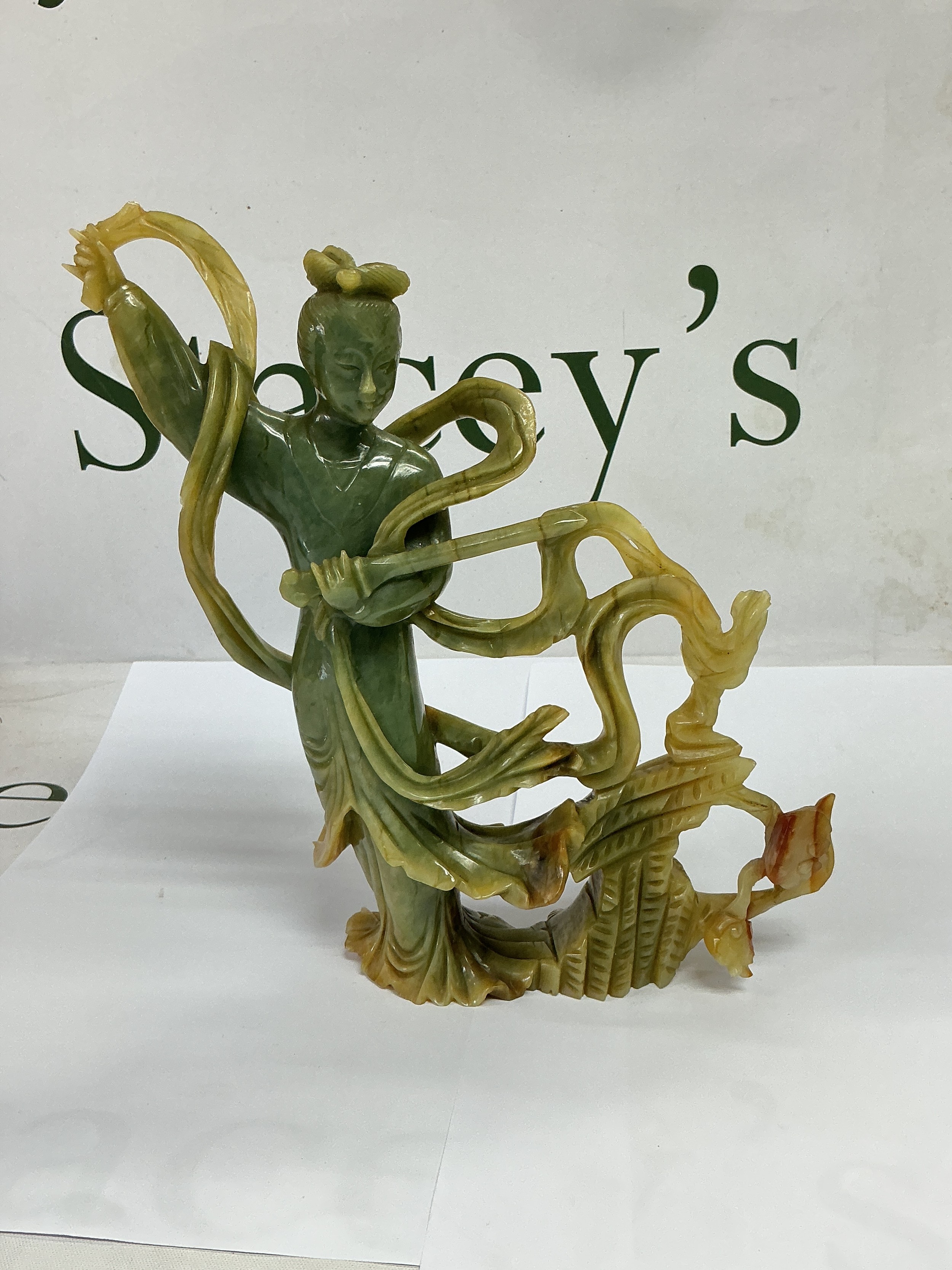 A soapstone carving of a figure wielding a scythe, approx height 22cm.