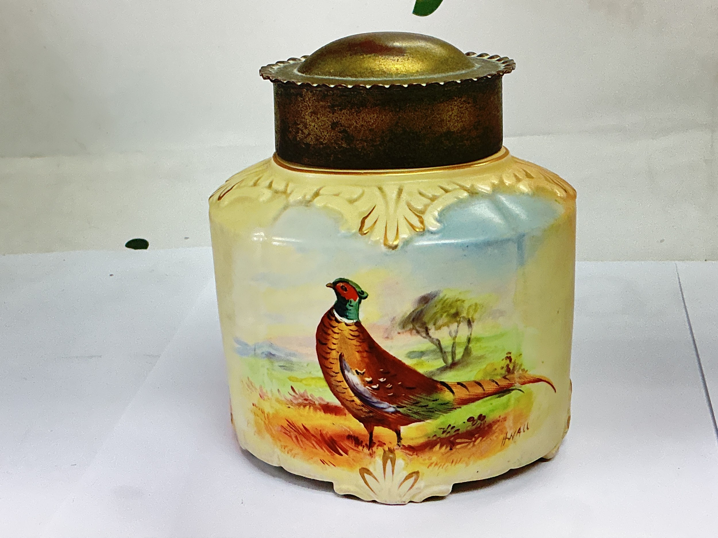An early 20th Century Locke & Co blush ivory jar and cover with hand painted decoration of a pheasant, approx height 12cm.