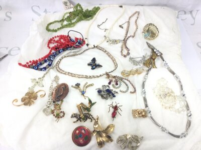 A mixed collection of costume jewellery including brooches, necklaces