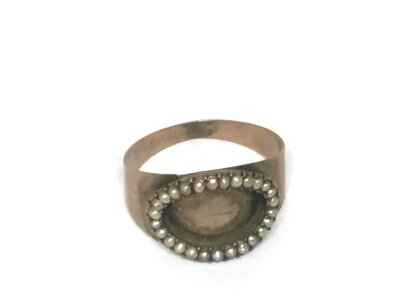 An Antique Mourning gold ring unmarked set with an oval of seed pearls. Weight 2.5g