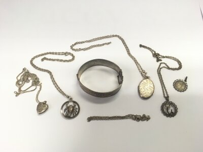 A silver bangle , pendants and chains.