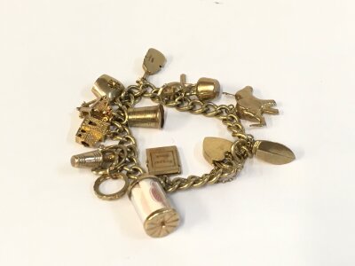 A 9ct gold charm bracelet with assorted charms.
49.40g