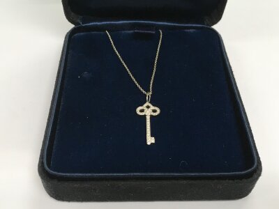 A boxed Tiffany & Co fleur de lys platinum and diamond necklace with original receipt from Harrods, approx 3.8g.