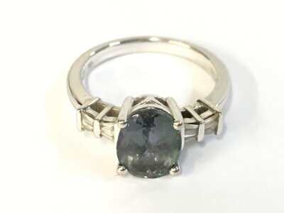 An 18ct white gold ring set with Peacock Tanzanite and diamonds. Size N 1/2 and 5.30g
