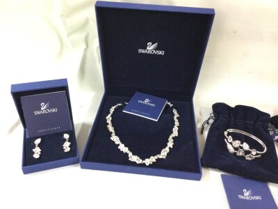 A boxed Swarovski jewellery suite includes bracelet, earrings and necklace