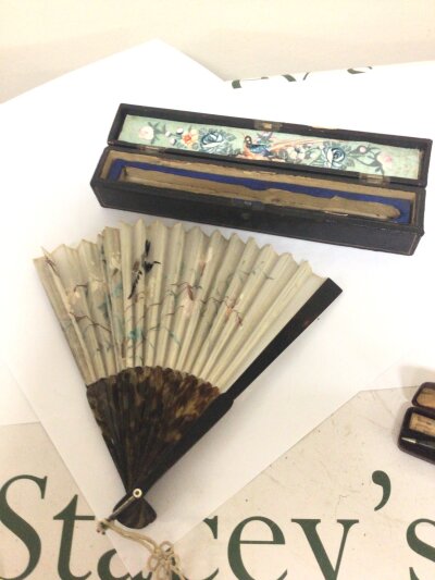 A 19th century tortoiseshell and silk embroidered fan in a lacquer box with a hand painted panel. Good condition in keeping with age.