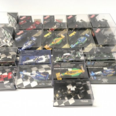 A collection of 19 model F1 racing call all in display boxes.