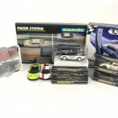 A box containing a collection of Scalextric cars as pictured. Also included is a 2 car racer system. Plus a safety car challenger. No reserve.