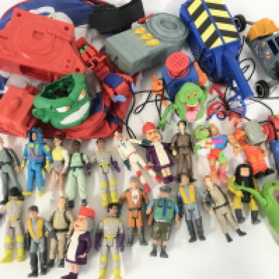 A Box Containing A Collection of Vintage Ghostbuster Figures And Accessories.