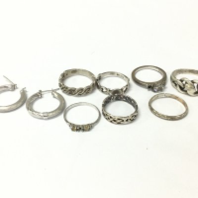 A collection of silver rings and a pair of silver earrings. Postage A
