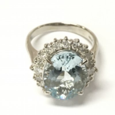 A platinum dress ring set with a large central oval aquamarine surrounded by RBC diamonds. Aquamarine 5.61ct eye clean. Diamonds 0.78ct G-H. With Gemologist report. Size L 1/2.