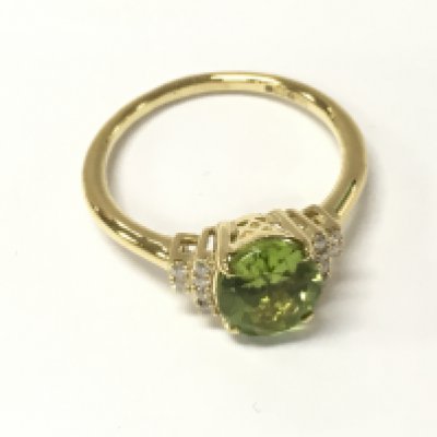 A 9ct gold ring set with an oval peridot flanked by diamonds in a terraced setting. Peridot 2.25ct and diamonds 0.11ct Approx. Size O