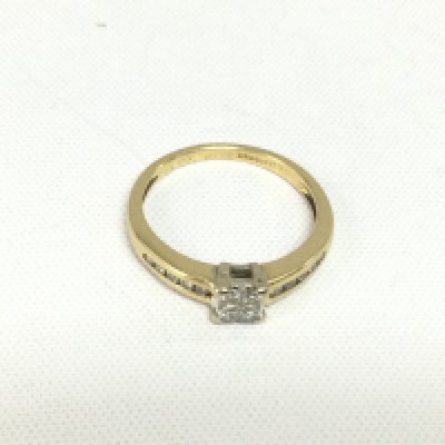 An 18ct gold diamond ring set with four central princess cut diamonds and smaller diamonds to the shoulders, approx 2.8g and approx size L-N. Shipping category A.