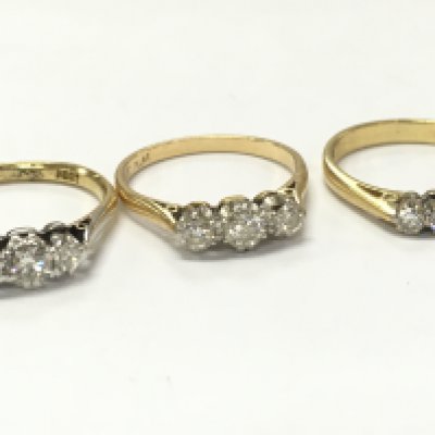 Three 18ct gold three stone diamond rings, 7.4g total weight. Postage category A