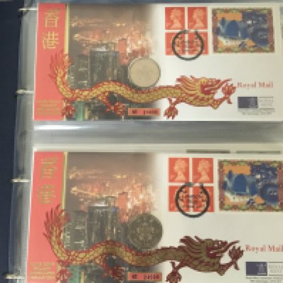 An Album containing a collection of Royal Mail Royal Mint Philatelic Numismatic Covers. in a blue album.