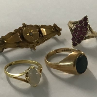 A gold brooch together with three rings including 9ct