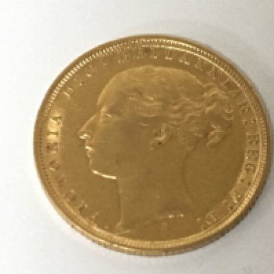 A Victorian 1884 gold sovereign with a young side profile portrait of Queen Victoria.