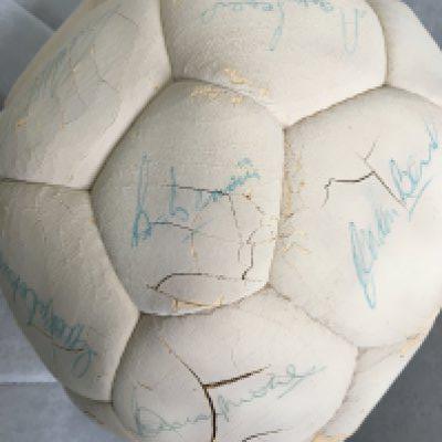 England 1970 World Cup Football: Old size 5 football hand signed in biro by Moore, Banks, Cohen, Hurst, Stiles, J Charlton, Hunt, Peters, Bonetti, Hunter and a few others. Please note Ball is old and beginning to crack and some autographs, including Bobby Moore, have a crack through them. Could well cover 1966 team as well. C/W 1966 World Cup tournament programme. (2)