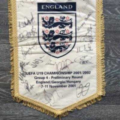 England 2001 Signed U19 Football Pennant: Official England pennant given to players and officials which states England, Georgia and Hungary from 7-11 November 2091. Hand signed by 19 of the England squad. Couple of marks to rear. This team had Dean Ashton, Jermaine Jenas and Glen Johnson.