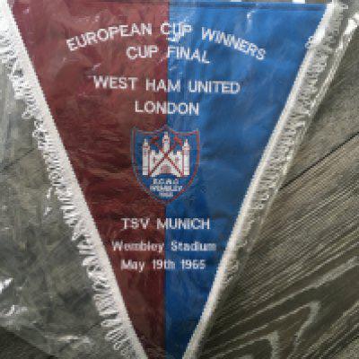 West Ham 1965 ECWC Final Pennant + Signed Shirt: Very large padded pennant with match details of the game v TSV Munich. C/W Toffs replica medium West Ham shirt signed by Hurst + Peters. (2)