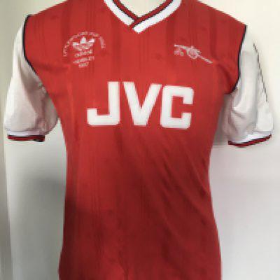 Arsenal 1987 League Cup Final Match Worn Football Shirt: Red short sleeve number 3 shirt with Littlewoods Cup Final 1987 Wembley 1987 under Adidas logo all embroidered. Framed white card reads This was the shirt that I wore when Arsenal won the Littlewoods Cup in 1987 against Liverpool. I was the captain and we won 2-1 signed by Kenny Sansom. Also comes with two signed press photos of Sansom wearing the shirt holding the cup on the pitch.