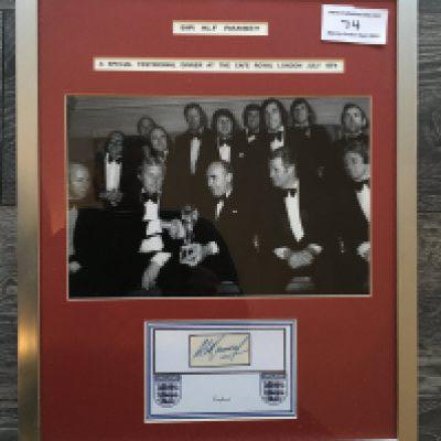 Alf Ramsey Signed 1966 England World Cup Display: Large black and white photo of the team in dinner suits with Alf holding a World Cup. Message reads Sir Alf Ramsey A special testimonial dinner at the Cafe Royal London July 1974. Ramseys autograph is attached to a white card in this attractive display. Red mount and silver frame measuring 15 x 19 inches.