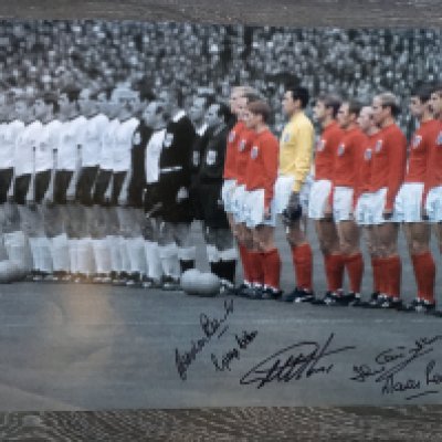 England 1966 World Cup Signed Football Print: Both teams lining up before the final with England players in colour and the rest of the print is black and white. Hand signed clearly in black marker pen by Peters, J Charlton, Hurst, Cohen and Banks. Measures 16 x 11 inches.