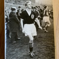 George Best + Denis Law Signed Football Picture: Large colour magazine picture featuring both Manchester United players in their respective Scotland and Northern Ireland kits. Both clearly hand signed without dedication. Measures just over 8 inches square.
