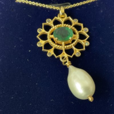 Fancy pendant in yellow metal set with diamonds, an oval metal emerald with a suspended pearl on a gold plated silver chain, boxed. Emerald 1.00ct approx. Diamonds 0.08ct approx. Postage category A.