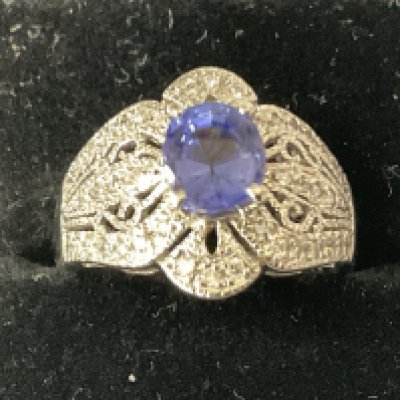 Stylish platinum ring with an oval tanzanite and inter pierced ornate diamond surround, boxed. Tanzanite 1.52ct. Diamonds 0.28ct. Ring size approx M. Postage category A.