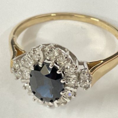 9ct yellow gold art deco style oval sapphire and R/C diamond cluster ring. Sapphire 1.00ct approx. Diamonds 0.38ct. Ring size approx Q. Postage category A.